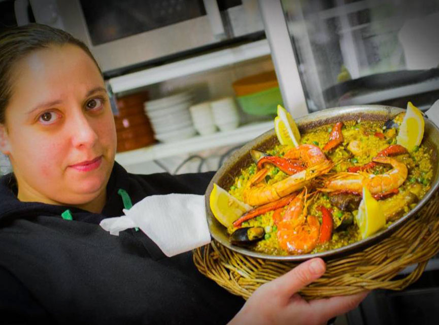 Palmitos mujer con paella en las manos